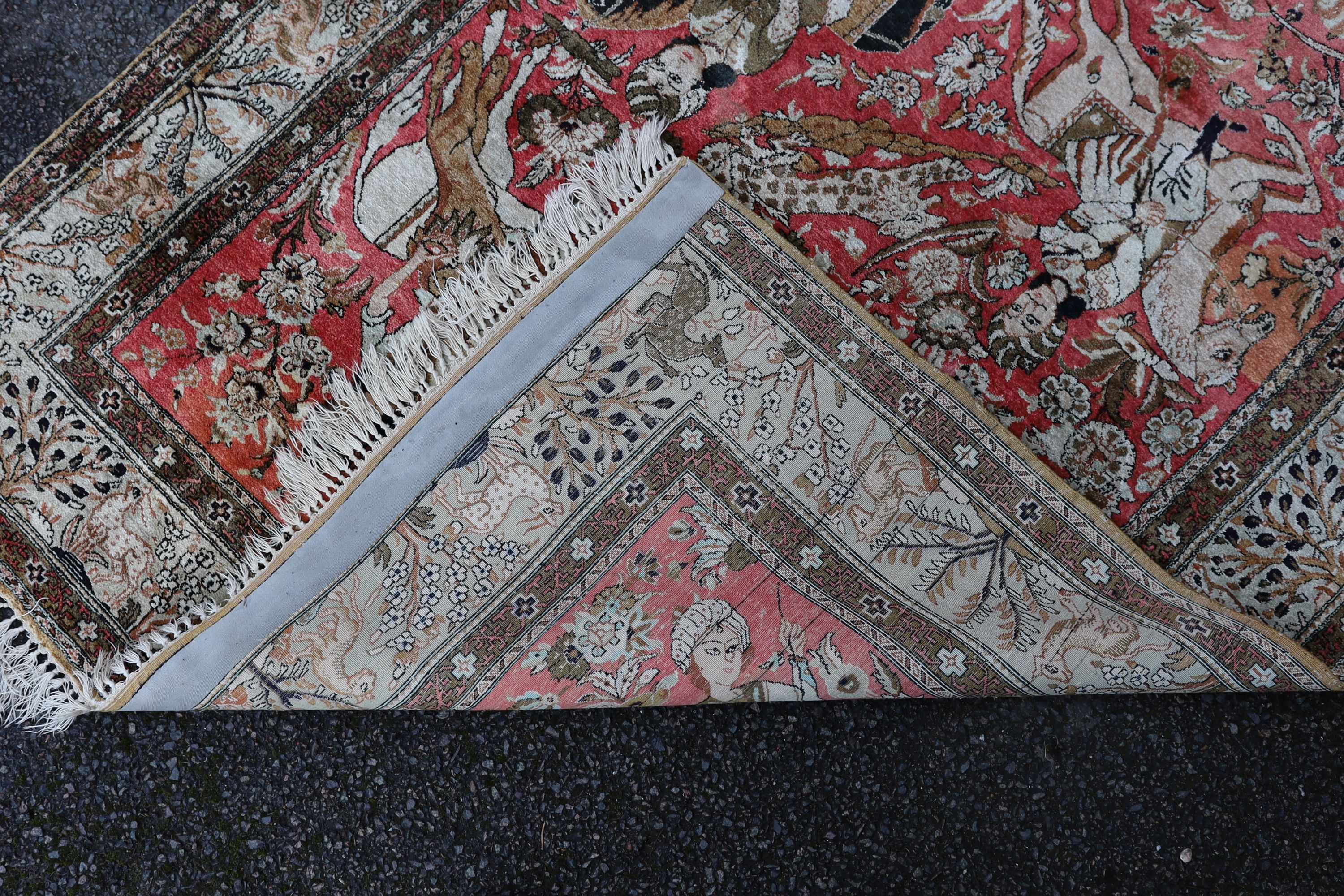 An early 20th century Tabriz pictorial red ground rug, woven with hunters on horseback, 208 x 135cm.